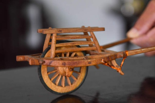 Carpenter makes wooden miniatures of farm tools