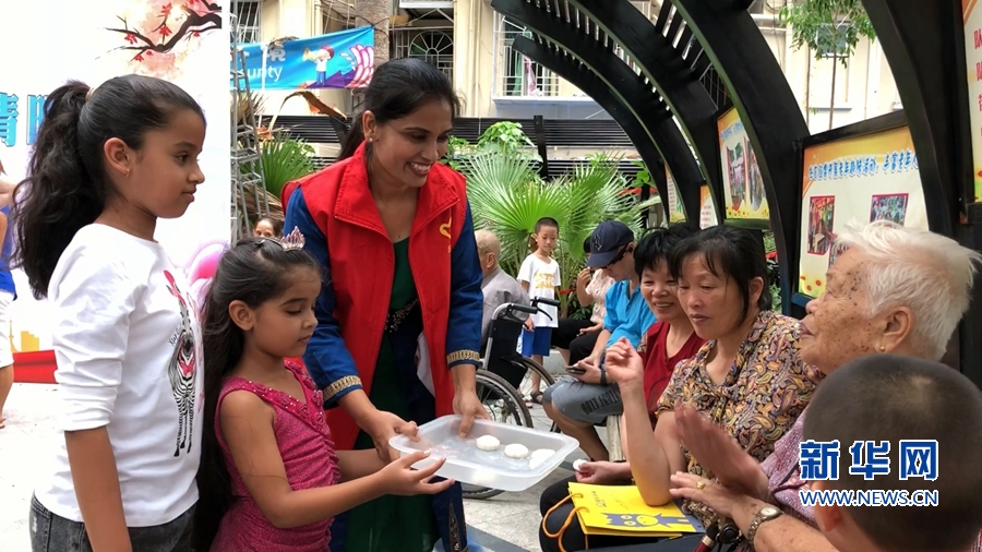 6　　卡尼卡在社区活动中，与孩子一起给社区老人送月饼。新华网肖和勇摄.jpg