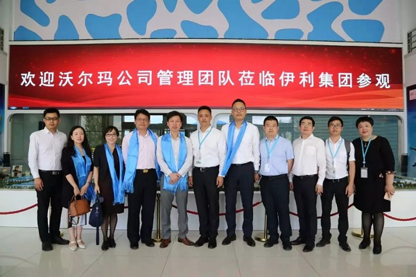 Yili’s and Walmart’s executives pose for a photograph when visiting Yili’s factories..png