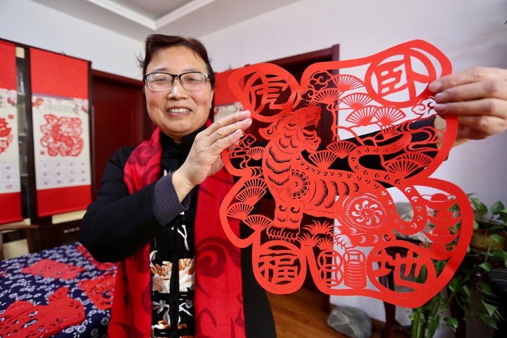 Female inheritor makes tiger-themed papercuts
