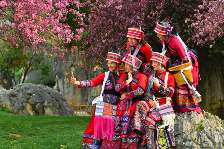 Yunnan people, dressed in ethnic costumes, enjoy beautiful spring