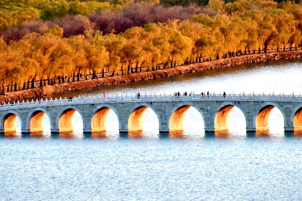 Setting sun shines through bridge in the Summer Palace in early winter