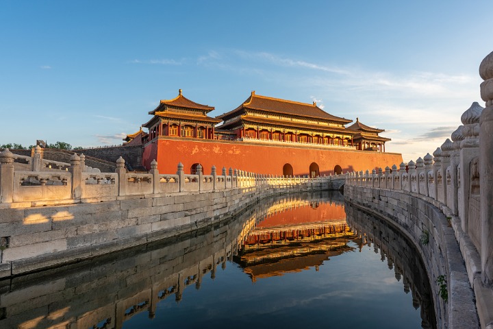 Principal gate of the Forbidden City reflected in river at sunset