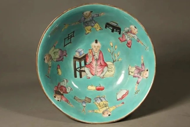 Qing Dynasty famille-rose bowl depicts 16 children against a green background