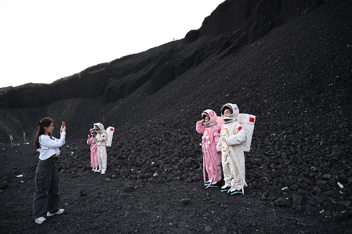Visitors wear space suits to explore Wulanhada Volcano Geopark in Inner Mongolia