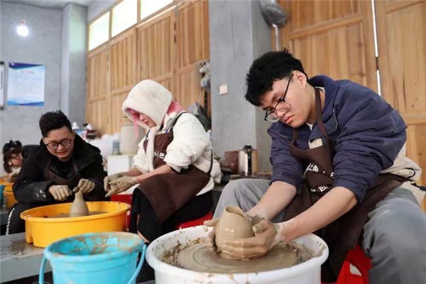 Young foreigners experience traditional craft in old town