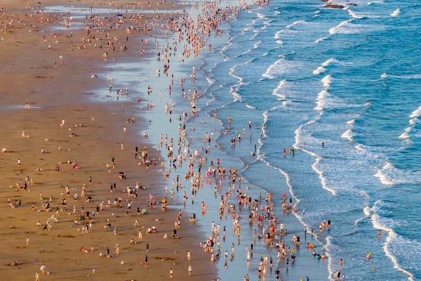 Qingdao’s seaside tourism remains popular as visitors cool off in the waves