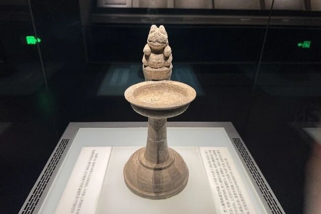 Ancient pottery iron decorated with a carved mythical beast