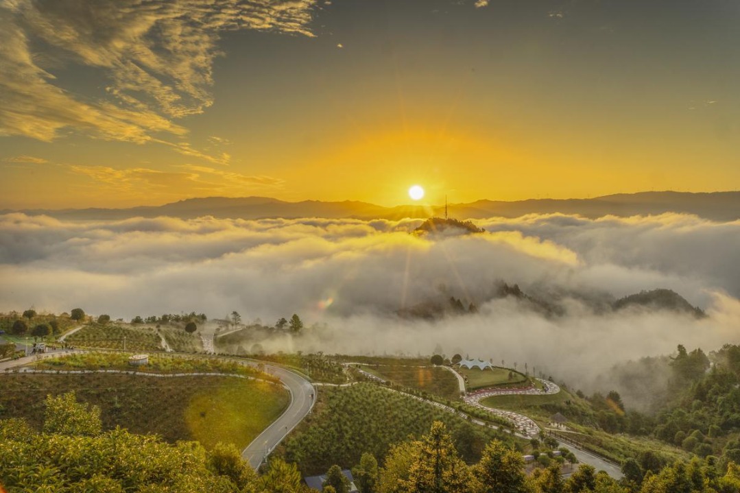 Clouds blanket Hunan mountain at sunrise, creating dreamy landscape